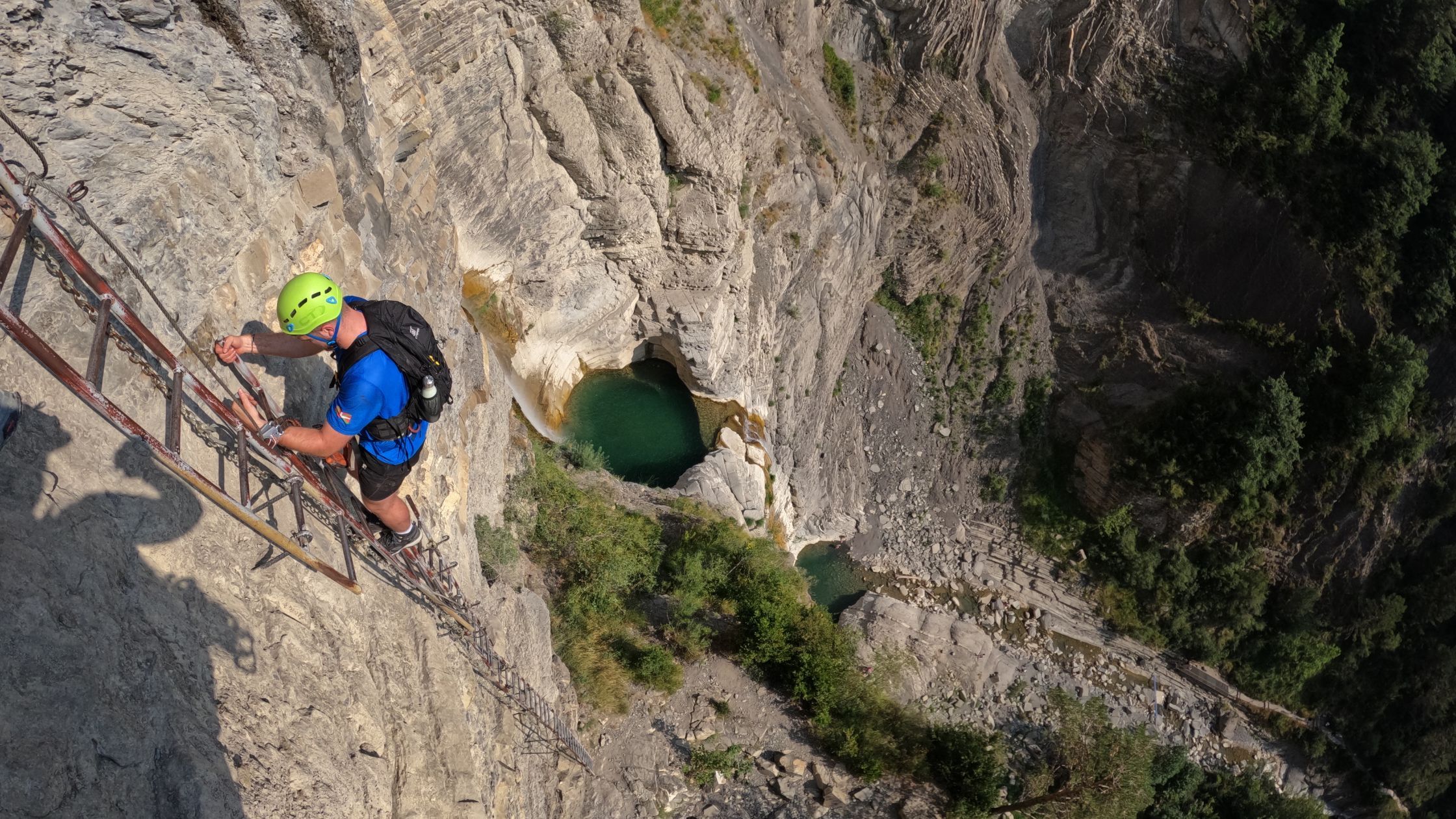via-ferrata-sorrosal-con-niños Participante en la vía ferrata del Sorrosal avanzando por el tramo vertical con vistas al barranco en Broto