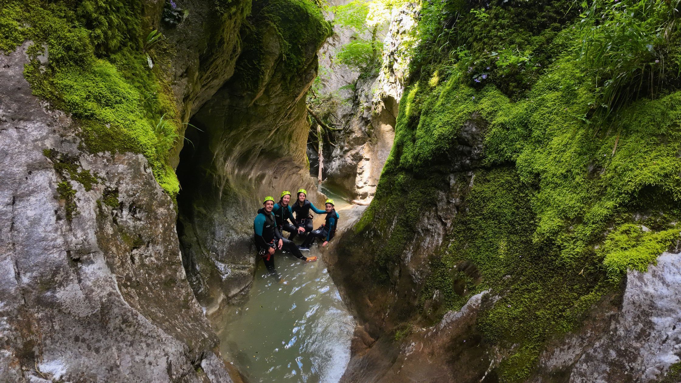 barranquismo-iniciacion-cerca-de-torla-ordesa Grupo de barranquismo de iniciación atravesando un espectacular cañón con paredes cubiertas de musgo y agua cristalina cerca de Torla Ordesa.
